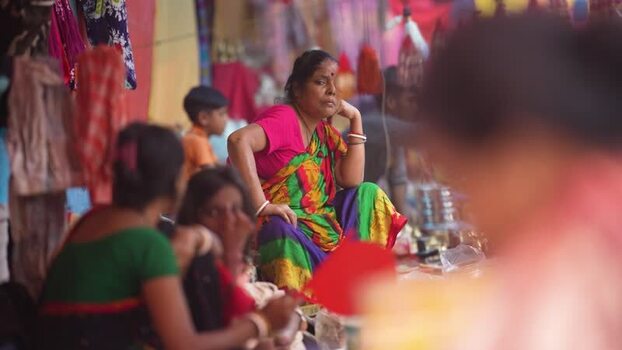 View of a woman sitting in a vibrant market in Rajshahi Bangladesh.