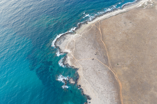 Aerial view of Riserva Naturale Orientata dello Zingaro with rugged coastal cliffs turquoise sea and winding paths through dry scrubland in San Vito Lo Capo Sicilia Italy. Aerial view of Riserva Naturale Orientata dello Zingaro with rugged coastal cliffs turquoise sea and winding paths through dry scrubland in San Vito Lo Capo Sicilia Italy.