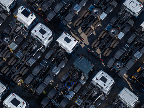 Aerial view of a fleet of industrial trucks parked in neat rows at a manufacturing facility in Spoleto Umbria Italy. Aerial view of a fleet of industrial trucks parked in neat rows at a manufacturing facility in Spoleto Umbria Italy.