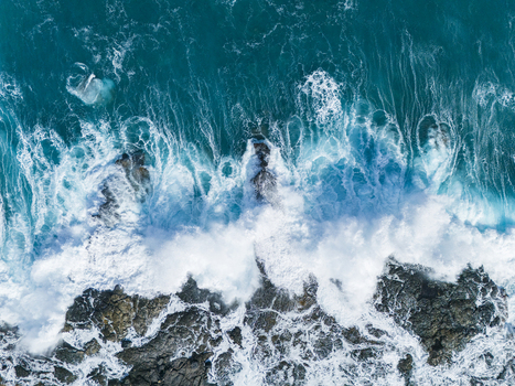 Aerial view of Kalaemamo coastline with turquoise waves crashing against dark volcanic rocks and white sea foam Hawaii County Hawaii United States. Aerial view of Kalaemamo coastline with turquoise waves crashing against dark volcanic rocks and white sea foam Hawaii County Hawaii United States.