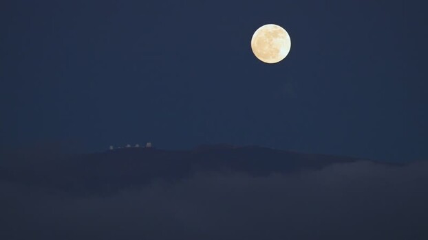 View of a full moon over a cloudy landscape United States. View of a full moon over a cloudy landscape United States.