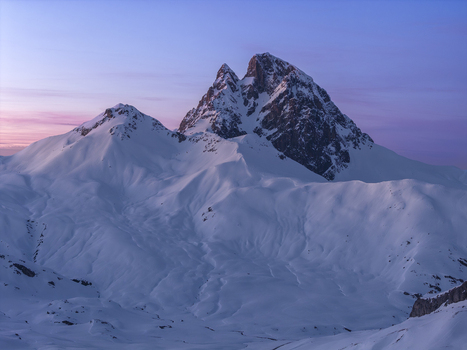 Aerial view of the snow covered Pyrenees mountains under a soft purple sunset sky in Spain. Aerial view of the snow covered Pyrenees mountains under a soft purple sunset sky in Spain.