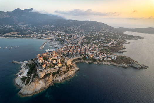 Aerial view of the historic Citadelle de Calvi on a rocky promontory overlooking the Mediterranean Sea with the marina and coastal town in Calvi Corse France.