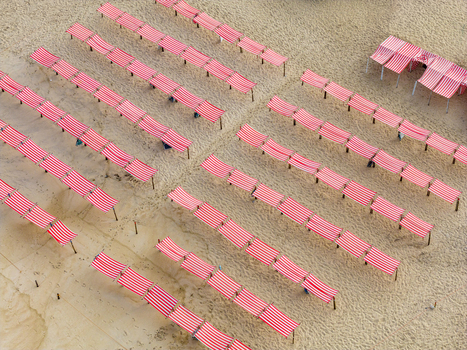 Aerial view of rows of red and white striped beach tents on the sandy shore of Praia de Sao Pedro de Moel in Marinha Grande Leiria Portugal. Aerial view of rows of red and white striped beach tents on the sandy shore of Praia de Sao Pedro de Moel in Marinha Grande Leiria Portugal.