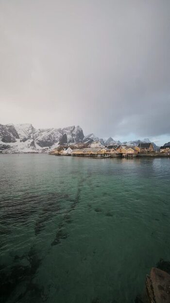 View of Hamn&oslash;y village and snow capped mountains Norway.