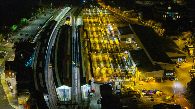 Aerial view of the illuminated Salisbury Railway Station at night with trains parked on the tracks and station platforms visible in Salisbury England United Kingdom. Aerial view of the illuminated Salisbury Railway Station at night with trains parked on the tracks and station platforms visible in Salisbury England United Kingdom.