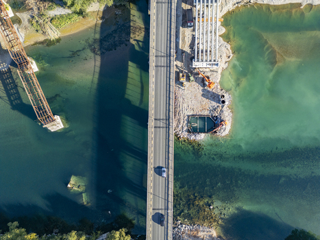 Aerial view of the Ura e Bahcallekut bridge over the Drin River showing construction work on the adjacent structure and turquoise water in Bahcallek Shkoder County Albania. Aerial view of the Ura e Bahcallekut bridge over the Drin River showing construction work on the adjacent structure and turquoise water in Bahcallek Shkoder County Albania.