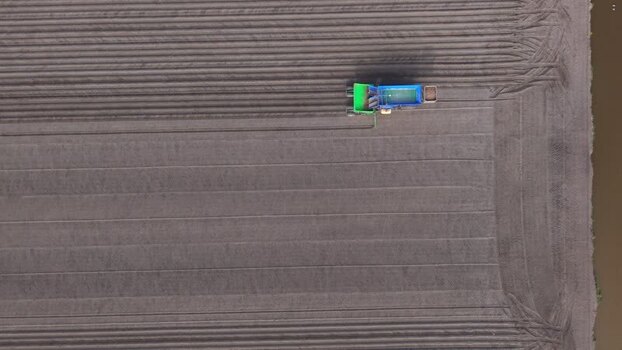 Aerial view of a tractor planting seeds in a field Netherlands.