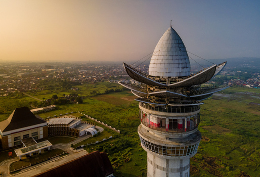 Aerial view of Menara Pandang Teratai tower with its lotus shaped top overlooking green fields and the city skyline during golden hour in Kecamatan Purwokerto Timur Jawa Tengah Indonesia. Aerial view of Menara Pandang Teratai tower with its lotus shaped top overlooking green fields and the city skyline during golden hour in Kecamatan Purwokerto Timur Jawa Tengah Indonesia.