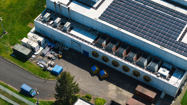 Aerial view of a data centre facility featuring solar panels on the roof and industrial cooling systems Wellingborough England United Kingdom. Aerial view of a data centre facility featuring solar panels on the roof and industrial cooling systems Wellingborough England United Kingdom.