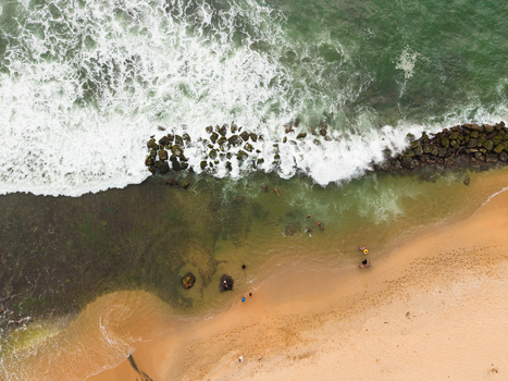 Aerial view of Dadalla beach with white waves crashing on the shore and people swimming in the turquoise water in Galle Southern Province Sri Lanka. Aerial view of Dadalla beach with white waves crashing on the shore and people swimming in the turquoise water in Galle Southern Province Sri Lanka.