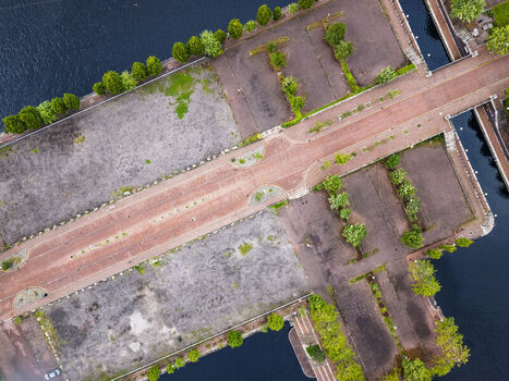 Aerial view of MediaCityUK featuring brick paved pathways and landscaped green spaces along the waterfront in Salford England United Kingdom. Aerial view of MediaCityUK featuring brick paved pathways and landscaped green spaces along the waterfront in Salford England United Kingdom.