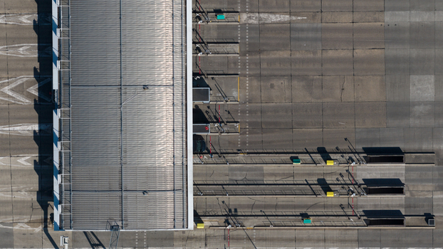 Aerial view of Gare de Peage de Dury toll station with multiple lanes concrete pavement and metal roof structure in Saleux Hauts de France France.