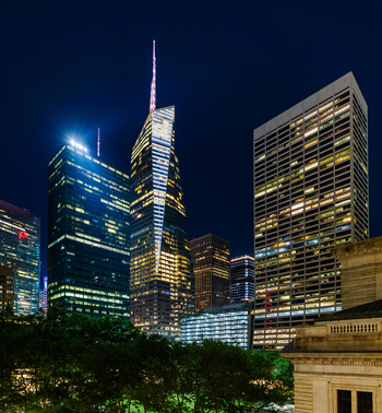 View of the illuminated Bank of America Tower and surrounding skyscrapers in Midtown Manhattan at night New York New York United States. View of the illuminated Bank of America Tower and surrounding skyscrapers in Midtown Manhattan at night New York New York United States.