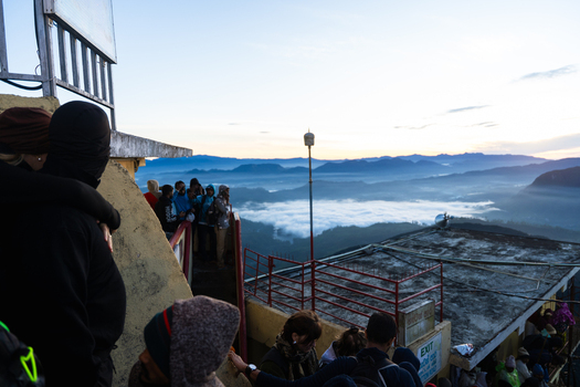 Ratnapura Sri Lanka 23 February 2026 View of people gathered at the summit of Adam s Peak overlooking a sea of clouds and mountain ranges at dawn.