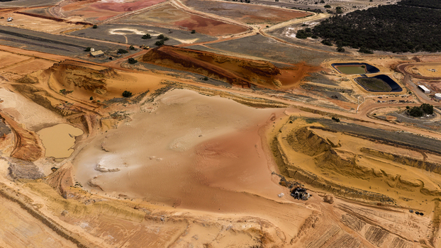 Aerial view of industrial salt and sand production site featuring vibrant mineral rich ponds textured earth and geometric excavation patterns in Kalbarri Western Australia Australia. Aerial view of industrial salt and sand production site featuring vibrant mineral rich ponds textured earth and geometric excavation patterns in Kalbarri Western Australia Australia.