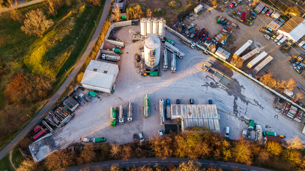 Aerial view of a bustling industrial site with silos trucks and warehouses bathed in the soft glow of the setting sun Prague 9 Prague Czechia. Aerial view of a bustling industrial site with silos trucks and warehouses bathed in the soft glow of the setting sun Prague 9 Prague Czechia.