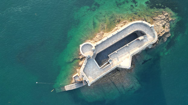 Aerial view of the Ch&acirc;teau du Taureau a stone fortress island standing resolute amidst the turquoise waters of the bay Plouezoc h Bretagne France.