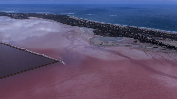 Aerial view of vibrant pink salt lakes and industrial salt pans near Useless Loop showcasing contrasting colors of sand and water in Kalbarri Western Australia Australia. Aerial view of vibrant pink salt lakes and industrial salt pans near Useless Loop showcasing contrasting colors of sand and water in Kalbarri Western Australia Australia.