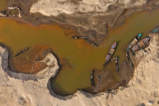 Aerial view of Jadukata River with wooden boats moored in shallow water along sandy banks in Sunamganj Sylhet Division Bangladesh. Aerial view of Jadukata River with wooden boats moored in shallow water along sandy banks in Sunamganj Sylhet Division Bangladesh.
