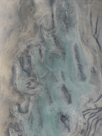 Aerial view of intricate tidal sand patterns and shallow water channels on the beach in Senja Troms Norway.
