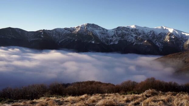 View of snow capped Balkan Mountains above clouds Bulgaria.