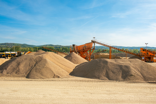 View of industrial gravel processing plant with large piles of sand and conveyor belts under a clear blue sky in Novi Sad Vojvodina Serbia. View of industrial gravel processing plant with large piles of sand and conveyor belts under a clear blue sky in Novi Sad Vojvodina Serbia.