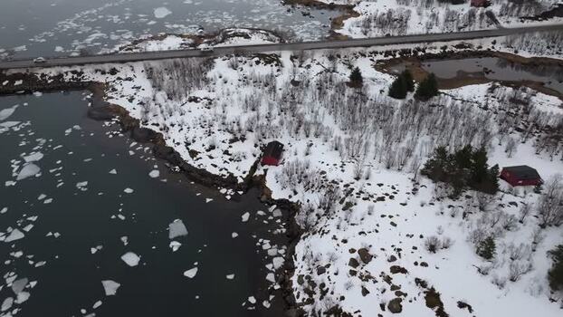 Aerial view of Lofoten snowy landscape with red cabins Norway.