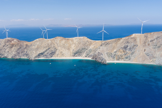 Greece 21 September 2026 Aerial view of a wind farm situated on the rugged rocky coastline with turquoise waters and clear blue skies. Greece 21 September 2026 Aerial view of a wind farm situated on the rugged rocky coastline with turquoise waters and clear blue skies.