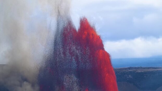 Aerial view of a massive lava fountain with red glow and ash.