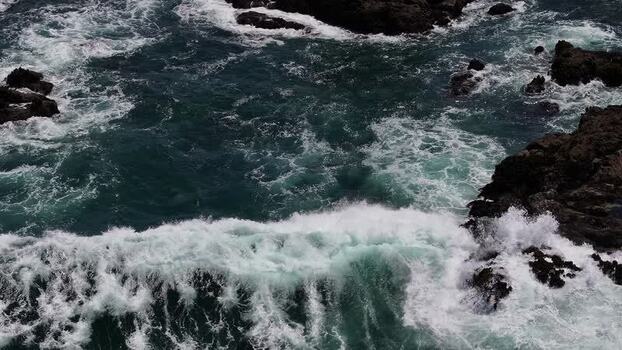 Aerial view of waves crashing against rocky cliffs United States.