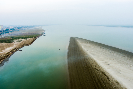 Aerial view of the wide Padma River with expansive sandbanks and the urban landscape of Rajshahi in the distance Rajshahi Rajshahi Division Bangladesh.