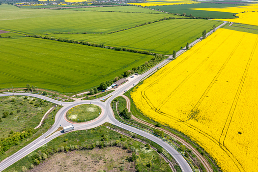 Aerial view of a road roundabout surrounded by vibrant yellow rapeseed and green agricultural fields Ploiesti Prahova Romania. Aerial view of a road roundabout surrounded by vibrant yellow rapeseed and green agricultural fields Ploiesti Prahova Romania.