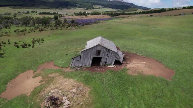 Aerial view of a weathered wooden barn in a field Chile. Aerial view of a weathered wooden barn in a field Chile.