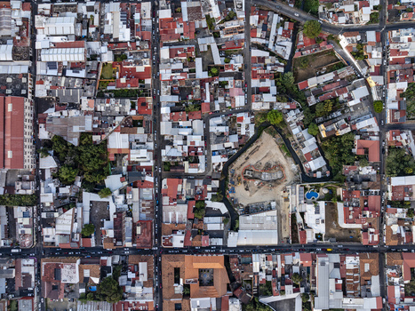 Aerial view of the dense urban landscape with red tiled rooftops narrow streets and a central construction site in Uruapan Michoacan Mexico. Aerial view of the dense urban landscape with red tiled rooftops narrow streets and a central construction site in Uruapan Michoacan Mexico.
