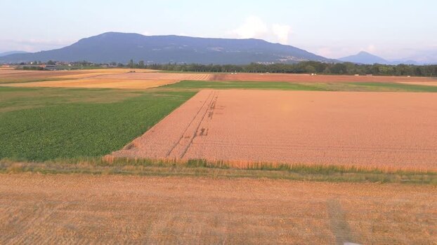 Aerial view of agricultural fields and mountains in rural Geneva Switzerland.