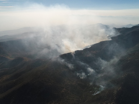 Aerial view of Sierra de San Miguelito showing thick smoke rising from a wildfire across the rugged mountain terrain in San Luis Potosi San Luis Potosi Mexico.