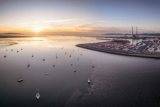 Aerial view of Dublin Port at sunset with sailboats moored in the calm bay and industrial shipping containers on the docks in Dublin County Dublin Ireland. Aerial view of Dublin Port at sunset with sailboats moored in the calm bay and industrial shipping containers on the docks in Dublin County Dublin Ireland.