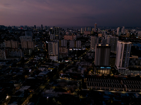 Aerial view of the illuminated cityscape of George Town at night featuring dense high rise buildings glowing street lights and urban infrastructure in George Town Penang Malaysia. Aerial view of the illuminated cityscape of George Town at night featuring dense high rise buildings glowing street lights and urban infrastructure in George Town Penang Malaysia.