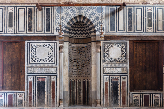 View of the Sultan al Ghuri Complex featuring intricate marble inlay geometric patterns and a central mihrab niche El Darb El Ahmar Cairo Governorate Egypt. View of the Sultan al Ghuri Complex featuring intricate marble inlay geometric patterns and a central mihrab niche El Darb El Ahmar Cairo Governorate Egypt.