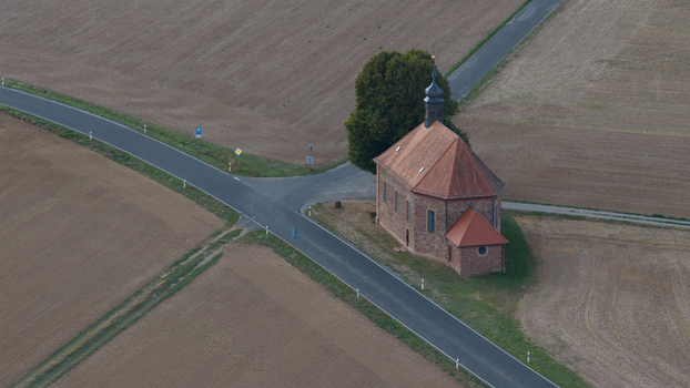 Aerial view of Wendelinuskapelle surrounded by agricultural fields and a rural road in Monchberg Bayern Germany. Aerial view of Wendelinuskapelle surrounded by agricultural fields and a rural road in Monchberg Bayern Germany.