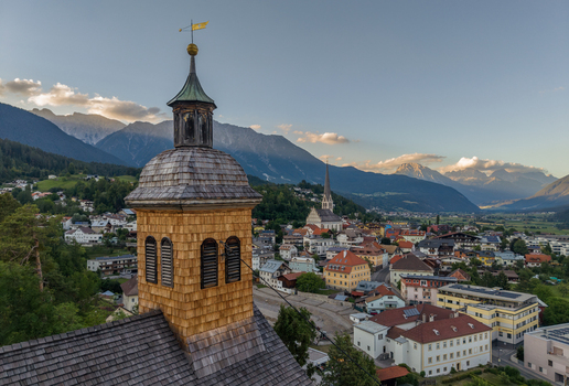 Aerial view of St. Laurentius Church overlooking the town of Imst nestled in the Austrian Alps at sunset Imst Tyrol Austria.