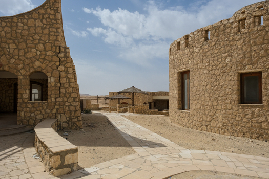 View of ancient stone buildings cast shadows on a winding stone path revealing the rustic charm of the desert landscape Cairo Cairo Governorate Egypt. View of ancient stone buildings cast shadows on a winding stone path revealing the rustic charm of the desert landscape Cairo Cairo Governorate Egypt.