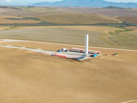 Aerial view of wind turbine components including blades and tower base at a construction site in the rolling hills Swellendam Western Cape South Africa. Aerial view of wind turbine components including blades and tower base at a construction site in the rolling hills Swellendam Western Cape South Africa.
