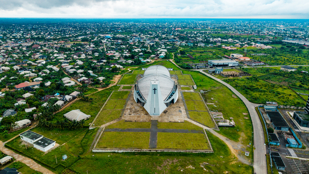 Aerial view of the modern Ibom Hall church building surrounded by expansive green grounds and the urban landscape of the city Uyo Akwa Ibom Nigeria. Aerial view of the modern Ibom Hall church building surrounded by expansive green grounds and the urban landscape of the city Uyo Akwa Ibom Nigeria.