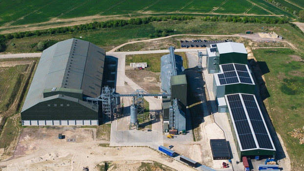 Aerial view of the Oat Milling Factory industrial complex featuring large warehouses storage silos and solar panel arrays surrounded by green agricultural fields in Kettering England United Kingdom. Aerial view of the Oat Milling Factory industrial complex featuring large warehouses storage silos and solar panel arrays surrounded by green agricultural fields in Kettering England United Kingdom.