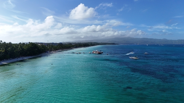 Malay Philippines 01 May 2026 Aerial view of Boracay Island featuring turquoise waters white sand beach and boats anchored near the tropical shoreline under a cloudy blue sky. Malay Philippines 01 May 2026 Aerial view of Boracay Island featuring turquoise waters white sand beach and boats anchored near the tropical shoreline under a cloudy blue sky.
