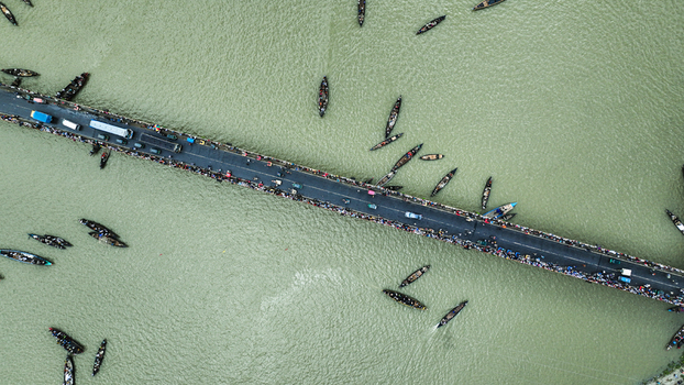 Baghabari Rajshahi Division Bangladesh 20 August 2022 Aerial view of the Baghabari bridge crossing the river surrounded by numerous small wooden boats and people navigating the water.