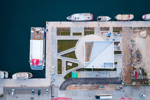 Aerial view of the new Pula AC Marina featuring modern architectural structures landscaped green areas and docked ships along the pier in Pula Croatia. Aerial view of the new Pula AC Marina featuring modern architectural structures landscaped green areas and docked ships along the pier in Pula Croatia.