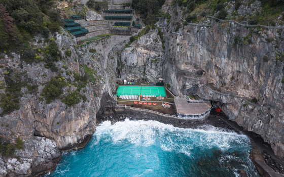 Aerial view of the Grotta dello Smeraldo where the turquoise waters meet the rugged cliffs creating a breathtaking contrast in Laurito Campania Italy. Aerial view of the Grotta dello Smeraldo where the turquoise waters meet the rugged cliffs creating a breathtaking contrast in Laurito Campania Italy.